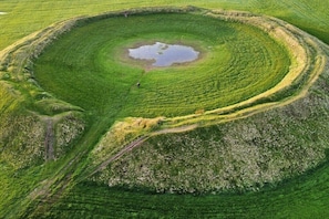 Ein kreisförmiger Hügel mit konzentrischen Ringen und einem Wasserbecken in der Mitte.