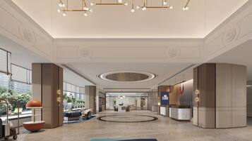A spacious lobby with a reception desk, seating area, and a large circular feature on the floor.