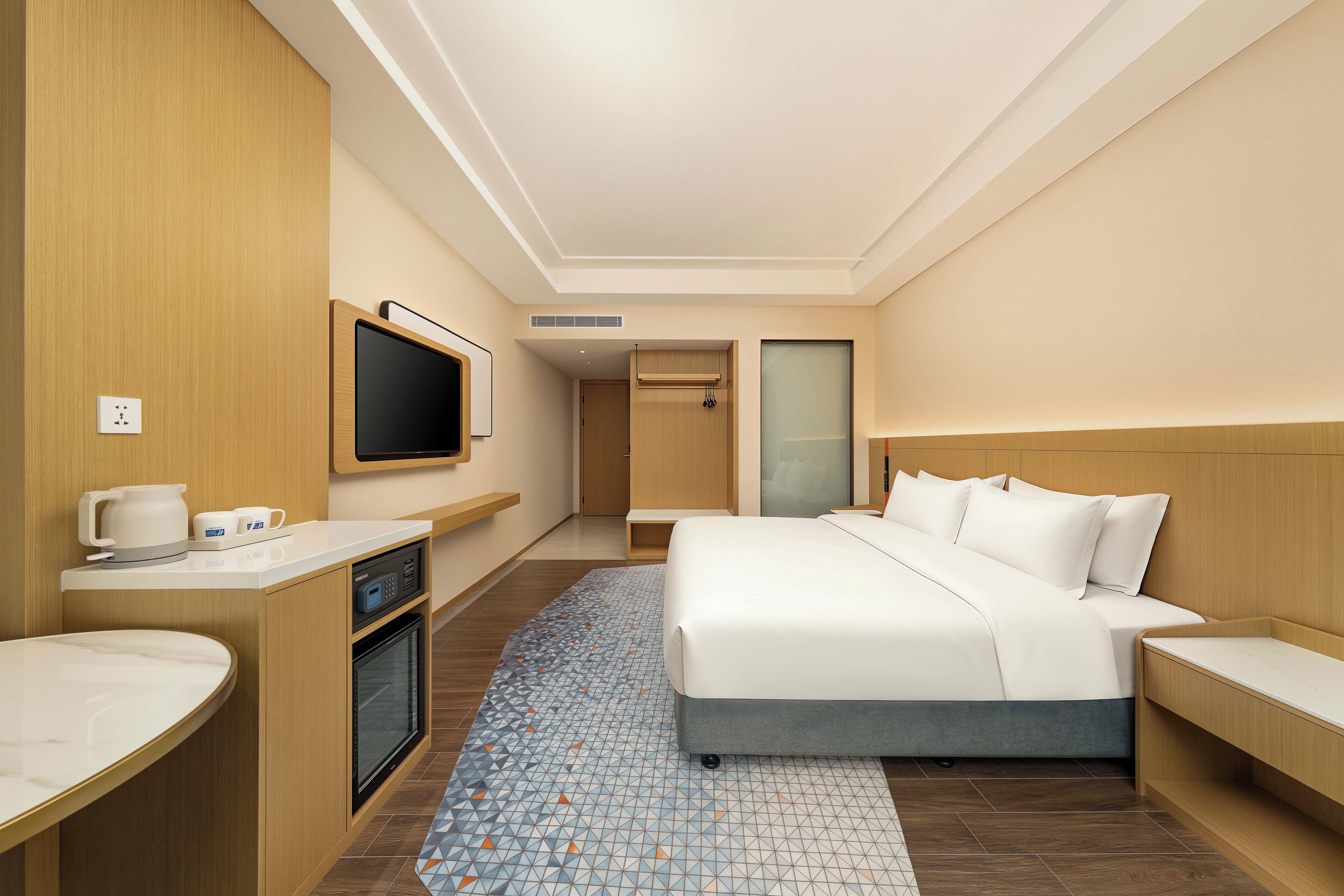 Een hotelkamer met een bed, een televisie, een koffiezetapparaat en een magnetron.