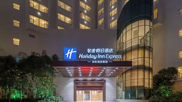 A Holiday Inn Express hotel entrance with a modern design, featuring a prominent signage, a glass facade, and a well-lit entrance area.