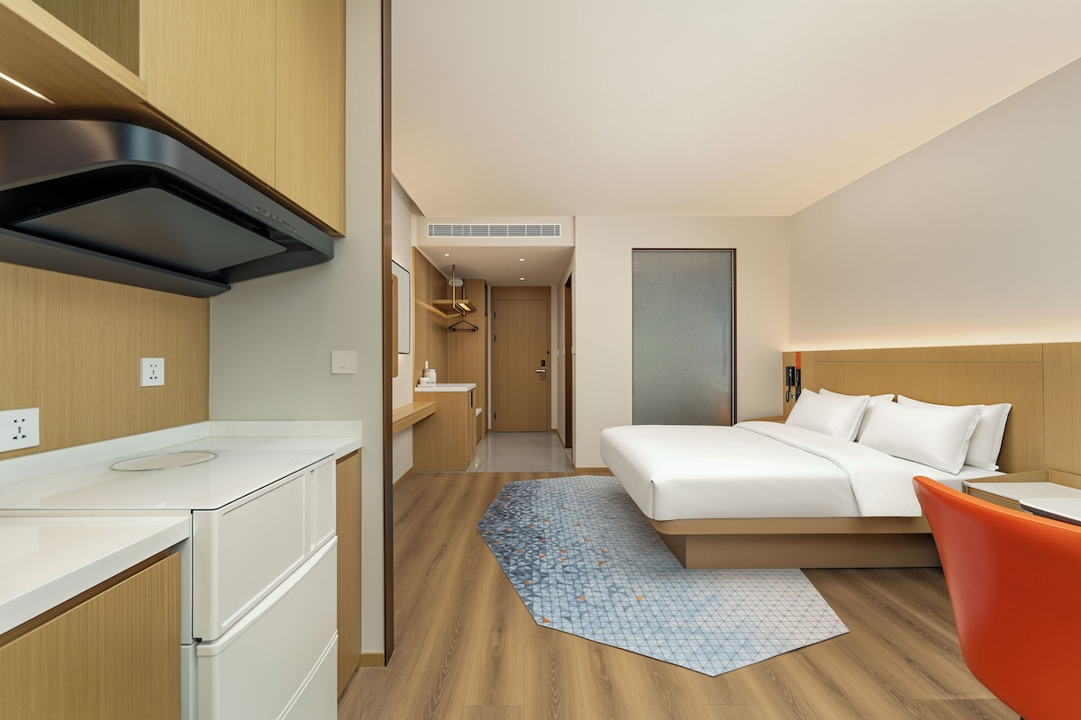 Una habitación de hotel moderna con una cama, un escritorio y una silla.