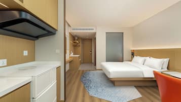 Una habitación de hotel moderna con una cama, un escritorio y una silla.