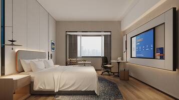 A modern hotel room with a large bed, a desk, a chair, a TV screen, and a city view.
