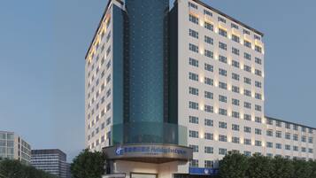 A hotel with a modern design, featuring a prominent glass facade and a sign for Holiday Inn Express.