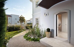 Ein modernes, zweistöckiges Haus mit gepflegtem Garten, sichtbarer Treppe und sauberer, weißer Fassade.