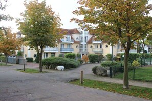 A residential building with a central courtyard, surrounded by trees and a paved walkway.