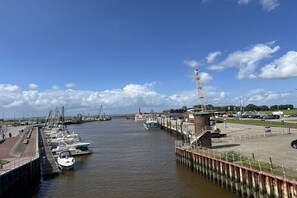 Ein Hafen mit vertäuten Booten, einer Mole und einem klaren Himmel.