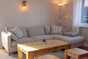 Ein Wohnzimmer mit einer Couch, einem Couchtisch und einer Stehlampe.