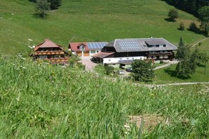 Ein Gebäude mit geneigtem Dach, Solaranlagen und traditioneller Holzkonstruktion mit rotem Dach.