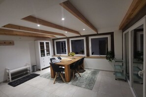 Ein Essbereich mit einem Holztisch, Stühlen, einem weißen Schrank und einem Fenster mit Blick.