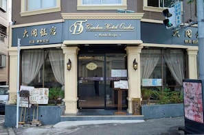 Un bâtiment sur lequel on peut voir une enseigne indiquant « Garden Hotel Osaka ».