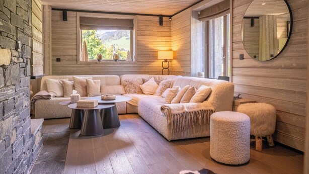 Ein gemütliches Wohnzimmer mit einer Eckcouch, einem runden Couchtisch und einem Kamin.