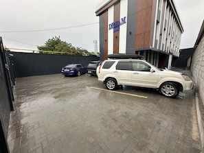 A parking area with two cars parked in front of a building labeled 'DREAM HOTEL.' - Dream Hotel Mayram (Kok-Jar)