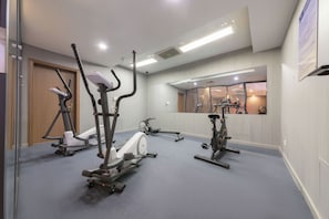 A gym with various exercise machines, a mirror, and a window with a view of the outside. - Days Inn Xi'an City Center (Xi'an)