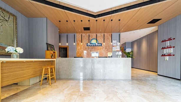 A reception area with a marble counter, wooden accents, and a sign for Days Inn. - Days Inn Xi'an City Center (Xi'an)
