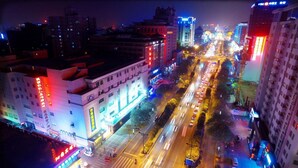 A nighttime cityscape with illuminated buildings and a busy street. - Days Inn Xi'an City Center (Xi'an)