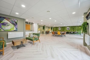 Ein modernes Interieur mit grüner Wand, einem Holztisch und einem Essbereich mit Stühlen und Tisch.