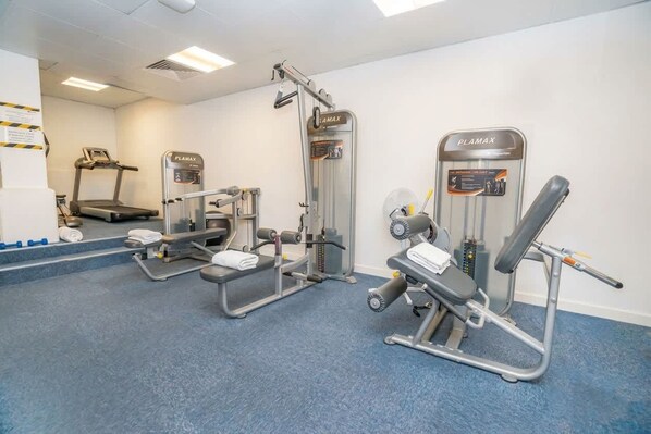 A gym with various exercise equipment including a treadmill, weight machines, and a bench press. - Coventry Budget Studio w/ Gym & Games Room (Coventry)