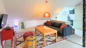 Ein modernes Wohnzimmer mit einer Couch, einem Couchtisch und einem Fernseher auf einem Lowboard.