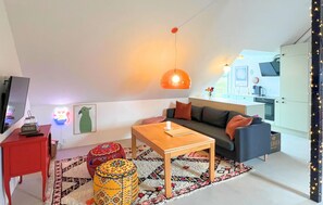 A modern living room with a sofa, coffee table, and a TV on a stand. - Gorgeous apartment in Ebeltoft with WiFi (Ebeltoft)