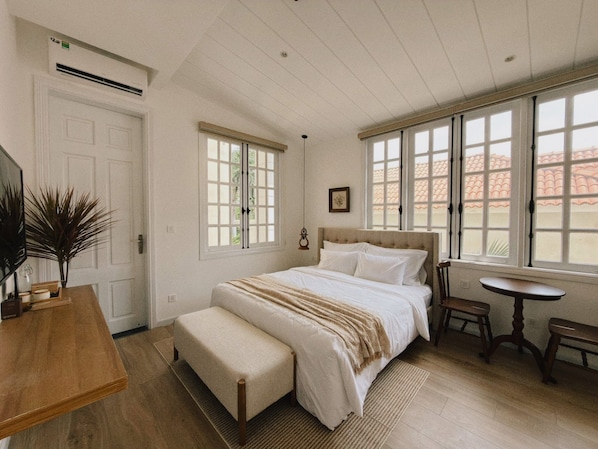 Quarto com cama, escrivaninha, cadeira, janela e porta.