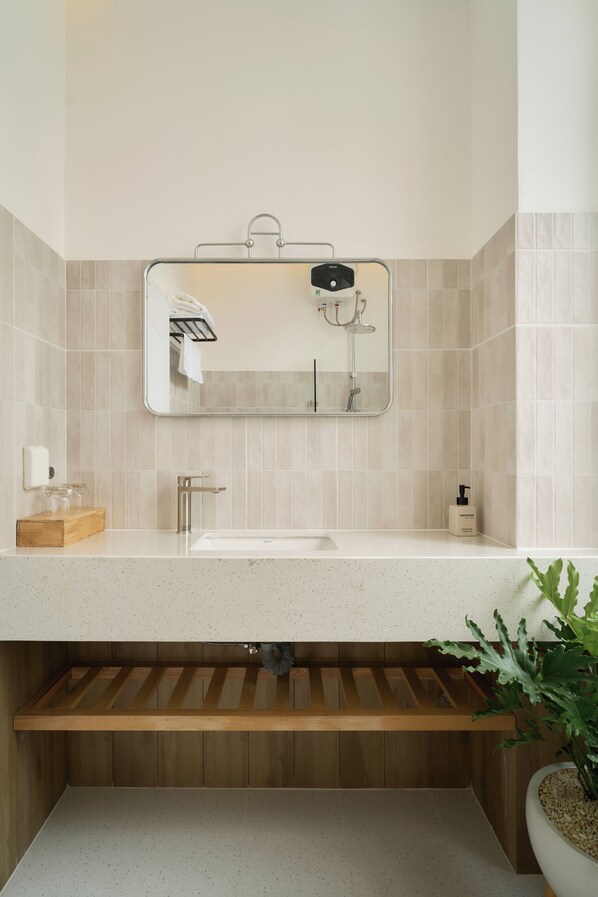 A bathroom with a mirror, sink, towel rack, and a wooden shelf. - Hanachi Stay Thao Dien (Ho Chi Minh City)