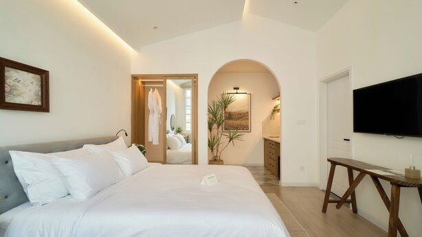 A hotel room with a large bed, a television, and a view of the hallway. - Hanachi Stay Thao Dien (Ho Chi Minh City)