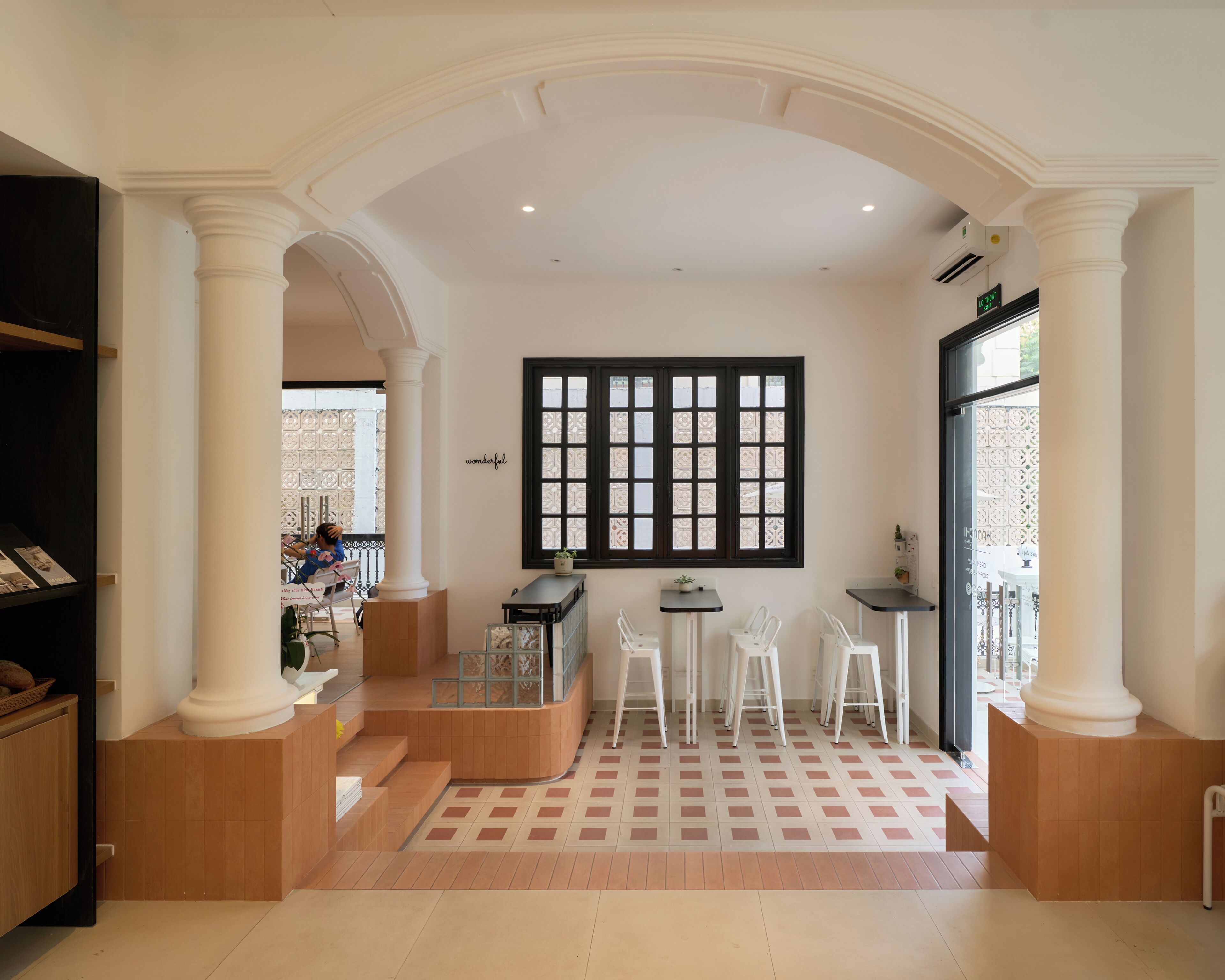 A spacious interior with a central seating area, a large window with decorative panes, and a view of the outside.