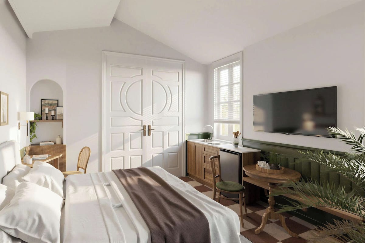 Un dormitorio con cama, escritorio, televisor y ventana.