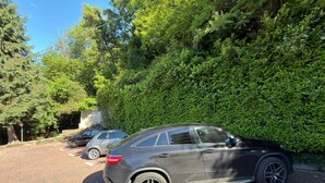 A parking area with a black car parked near a hedge. - Jager apartment with lake view in Verbania (Verbania)