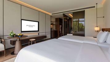 Habitación de hotel moderna con una cama grande, un escritorio con televisor de pantalla plana y vistas al exterior.