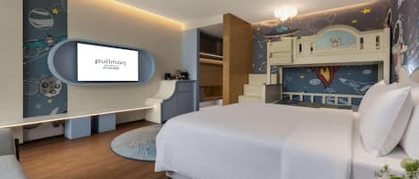 A modern hotel room with a large bed, a TV mounted on the wall, and a bunk bed with space-themed decor.