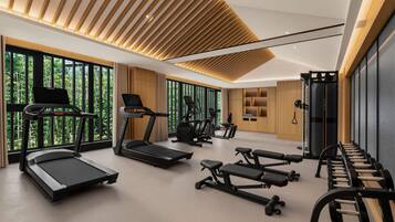A modern gym with treadmills, elliptical machines, and weight benches.