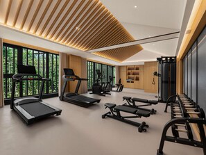 Ein modernes Fitnessstudio mit Laufbändern, Crosstrainern und Gewichtsbanken.