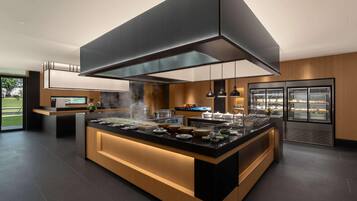 Una cocina moderna con una isla central, electrodomésticos integrados y una campana extractora grande.