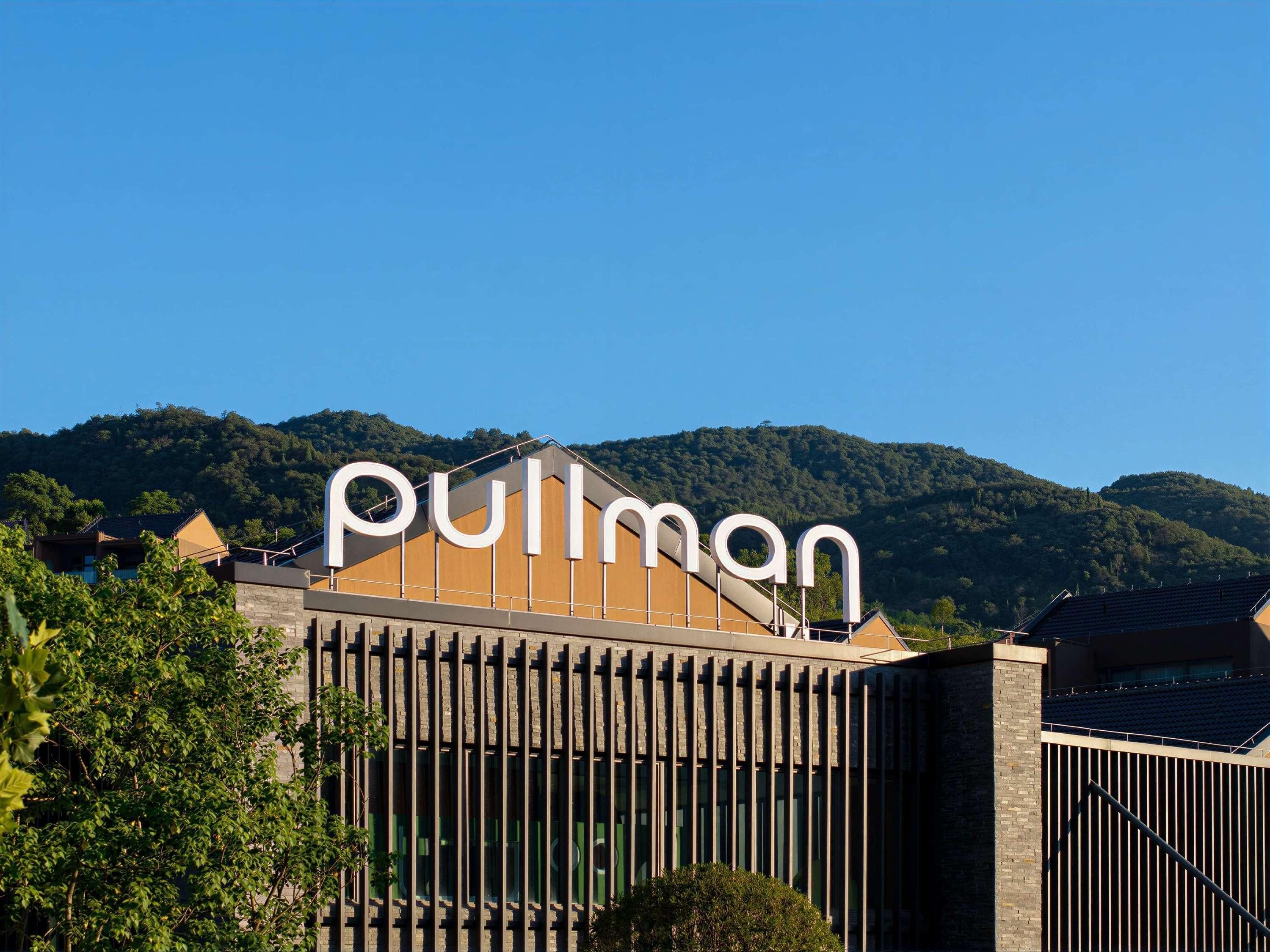 Un edificio con un letrero grande que dice 'Pullman' y un diseño arquitectónico moderno con líneas verticales.