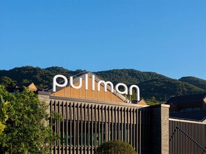 Ein Gebäude mit einer großen Schrifttafel, auf der 'Pullman' steht, und einem modernen architektonischen Design mit vertikalen Linien.