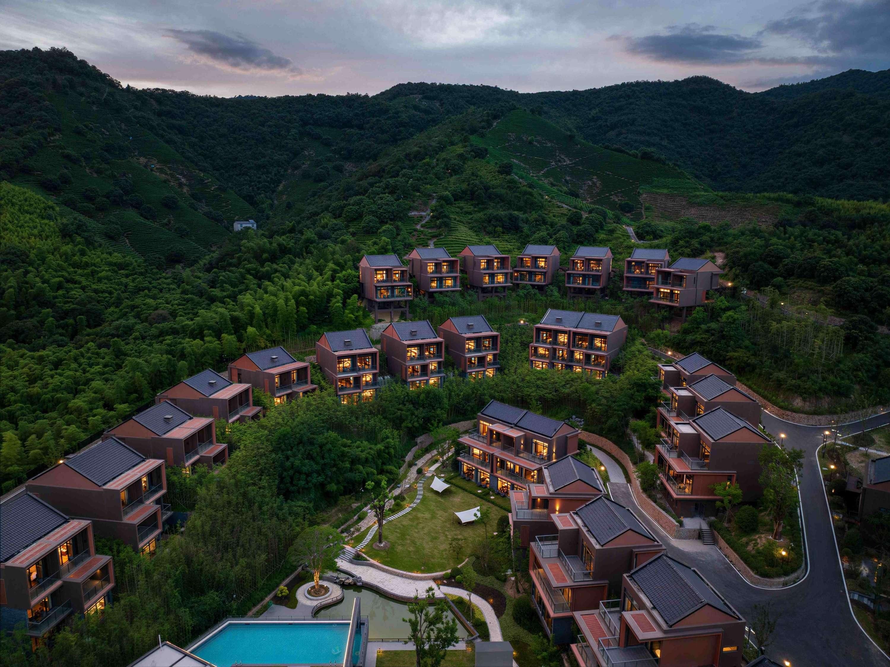 Un complejo residencial con varias edificaciones de dos pisos, una piscina y un camino sinuoso.