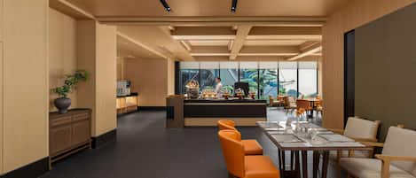 A modern hotel lobby with a central bar area, seating arrangements, and a view of the outdoors.