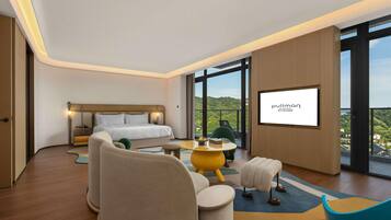 A hotel room with a bed, seating area, and a large window with a view.