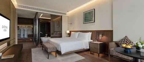 Una habitación de hotel moderna con una cama, mesita de noche, una zona de estar con una mesa y sillas.