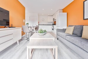 A modern living room with a sofa, coffee table, and TV. - Stay Zeni, Hardwick House Derby Modern 1 Bed Flat (Derby)