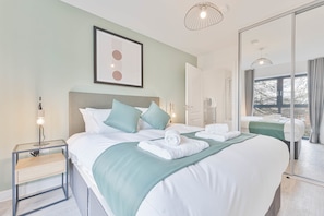 A hotel room with a large bed, bedside tables, a mirror, and a view of the outside. - Stay Zeni, Hardwick House Derby Lovely 2 Bed Flat (Derby)