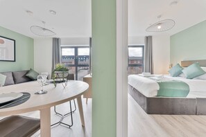 A modern hotel room with a dining area, a bed with a view, and a balcony. - Stay Zeni, Hardwick House Derby Lovely 1 Bed Flat (Derby)