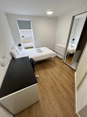 A bedroom with a bed, a desk, a chair, a dresser, a mirror, and a window. - Central Liverpool En-suites – Cosy & Affordable (Liverpool)