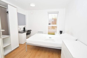 Ein modernes Schlafzimmer mit einem Bett, einem Schreibtisch und einem Kleiderschrank.