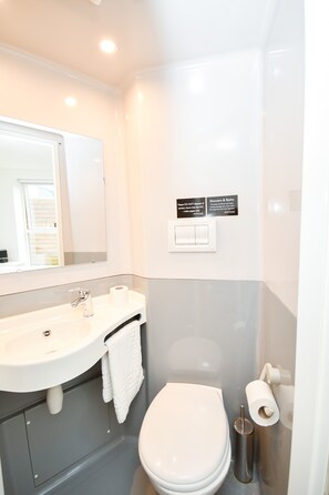 Ein Badezimmer mit Waschbecken, Toilette und einem Händetrockner.