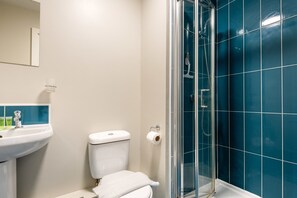 A bathroom with a toilet, sink, and shower. - Modern Budget Studio Apartment in Sheffield Centre (Sheffield)