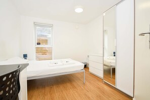 A bedroom with a bed, a window, a mirror, and a wardrobe. - Convenient 8 Bedroom Apartment in Liverpool (Liverpool)