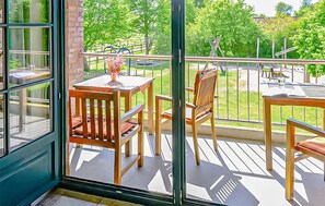 A balcony with a table and chairs, a flower vase, and a view of a park. - 2 bedroom stunning apartment in Ribnitz-Damgarten (Ribnitz-Damgarten)